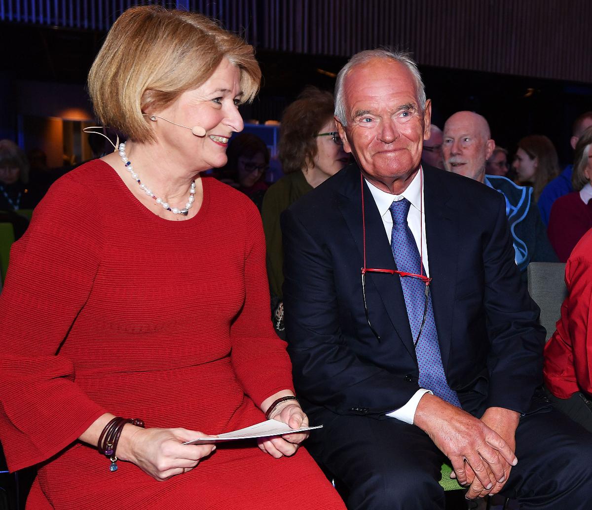 A happy woman and a happy man sitting in an audience.