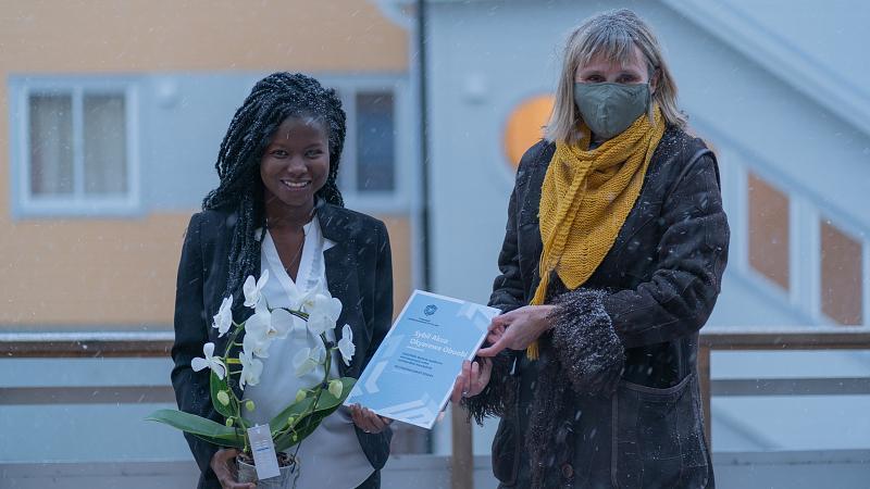 2 damer st&aring;r utend&oslash;rs, hvor ene mottar et diplom fra den andre