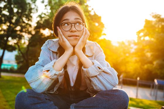 32505676-dreaming-young-teenage-girl-student-sitting-outdoors-in.jpg