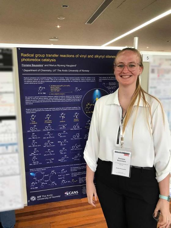 Floriane standing by her poster, smiling