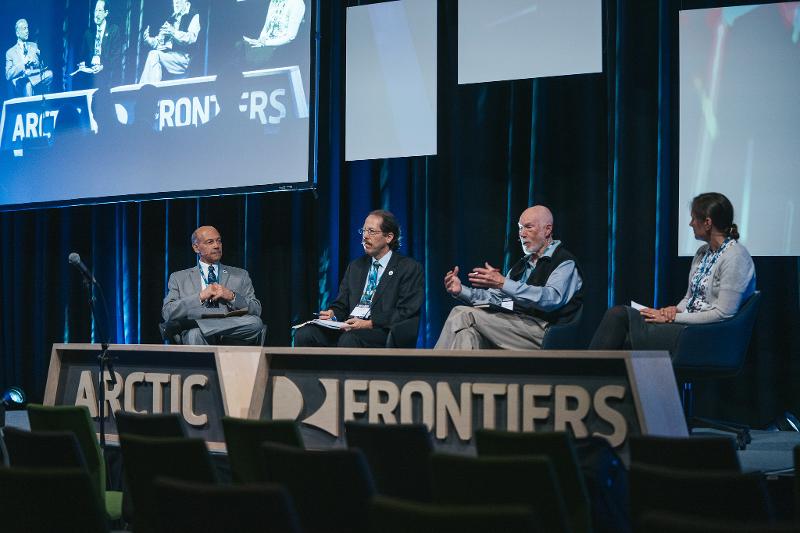 52179342581_c3c55b3f1f_k.jpg Fire personar på ei scene, i diskusjon. Foran dei eit stort skilt der det står Arctic Frontiers.