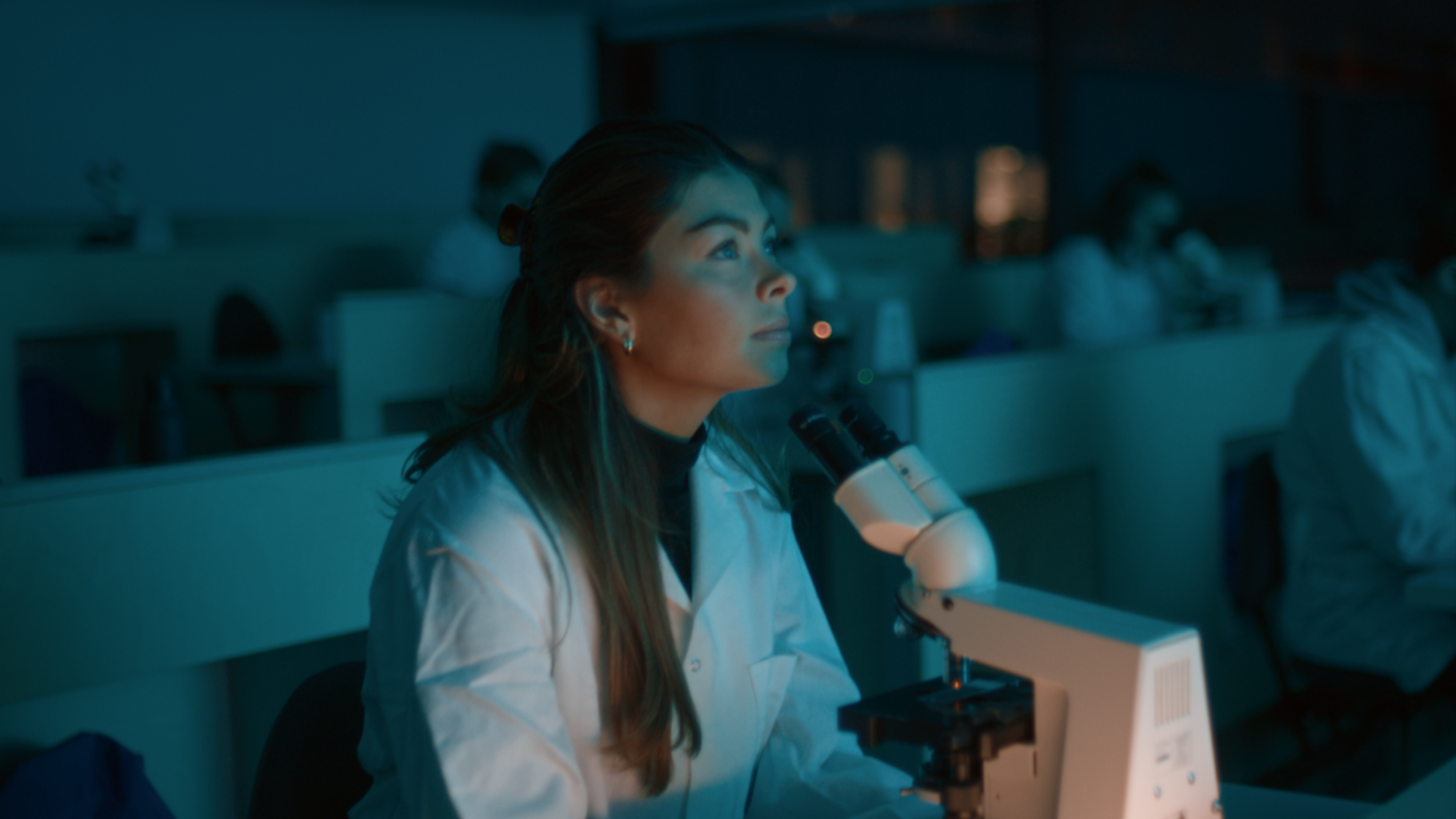 Kvinne sitter inne p&aring; et laboratorium
