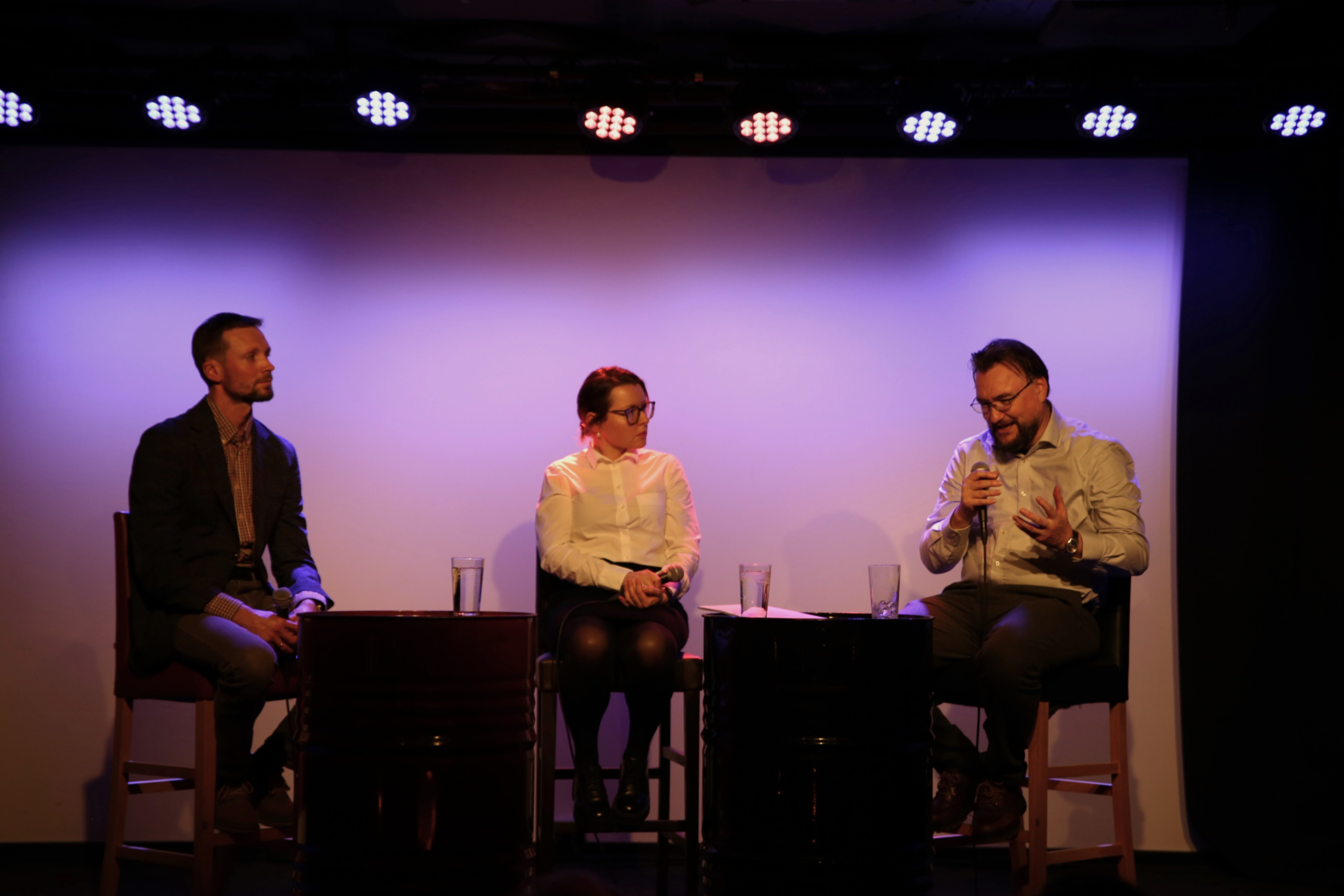 Tre paneldeltagere sitter p&aring; stol og er i en samtale. 