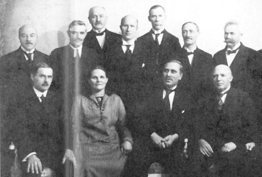 sort-hvitt foto av en gruppe menn og &eacute;n kvinne som poserer