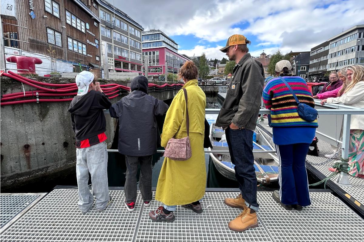 Personer som st&aring;r ved en brygge.
